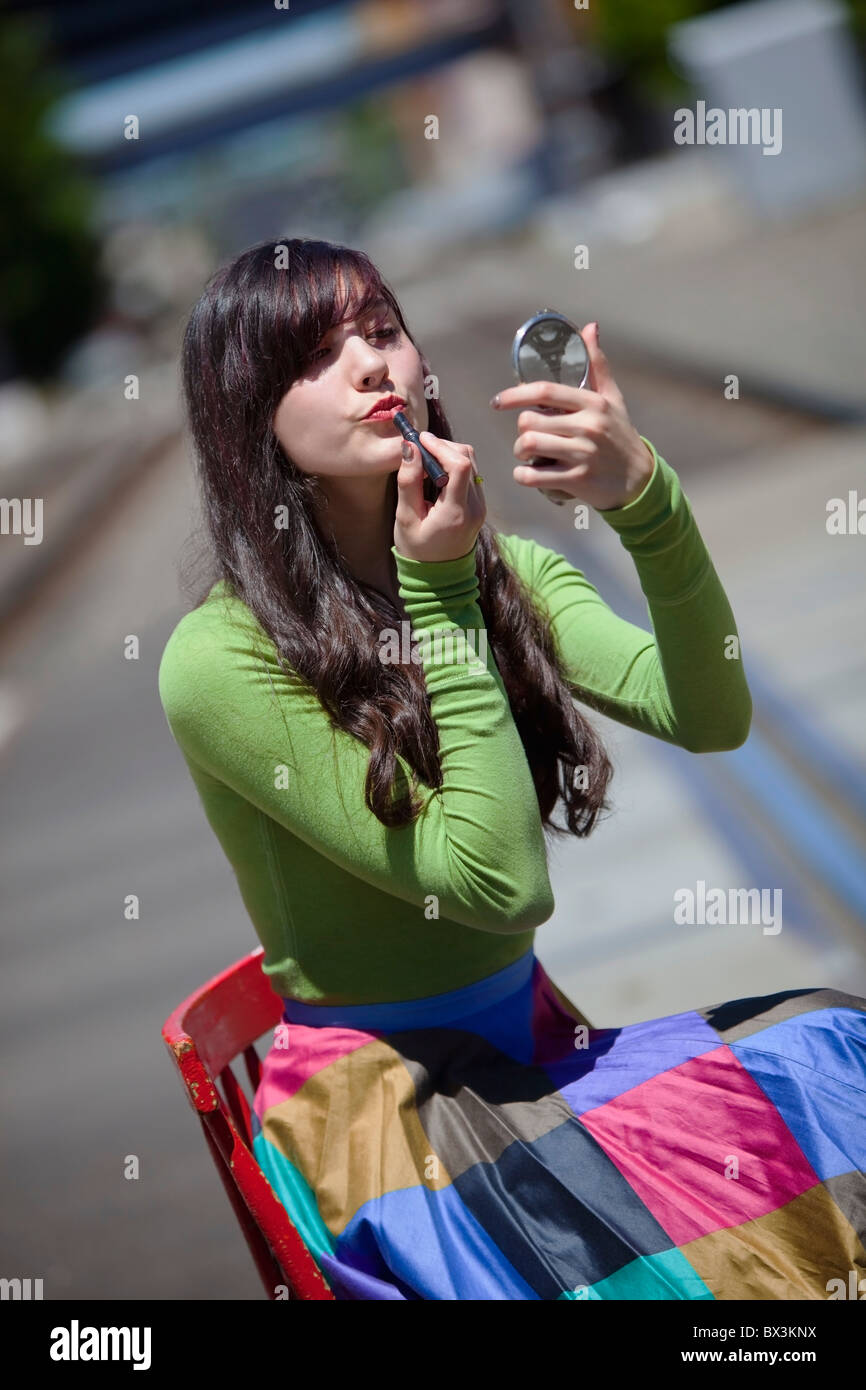 Teenage Girl Applying Lipstick; Portland, Oregon, United States Of America Stock Photo