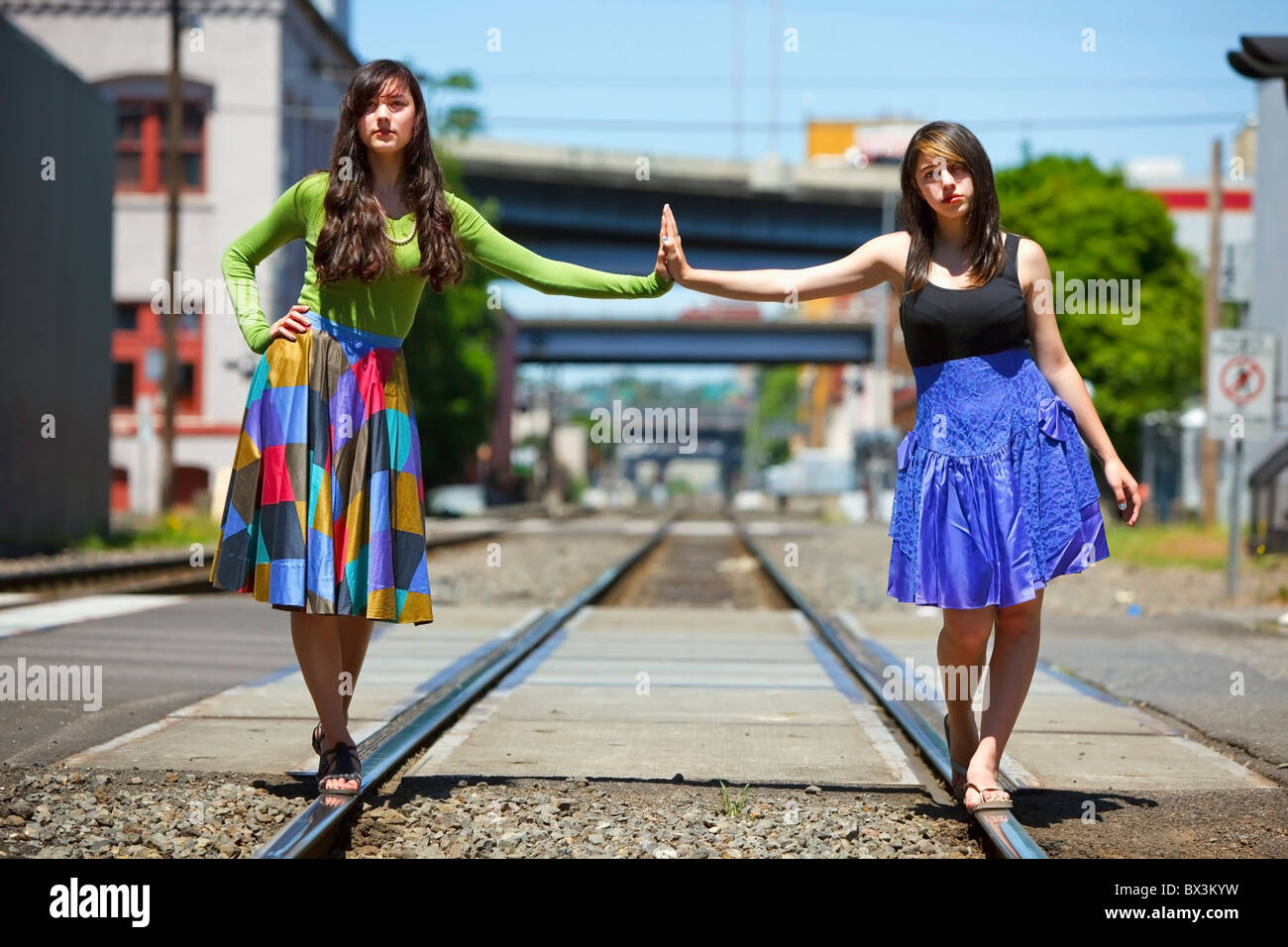 Teenage Girls Balancing On The Train Tracks Downtown; Portland, Oregon, United States Of America Stock Photo