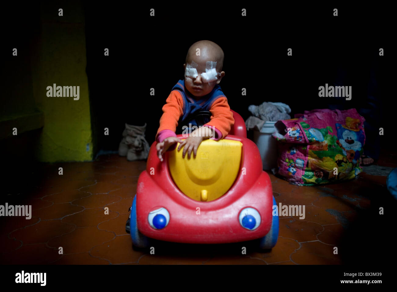 Jaira Cenovio Valdivia, 2, who suffers Retinoblastoma, a type of eye cancer, drives a toy car in Mexico City, Mexico. Stock Photo