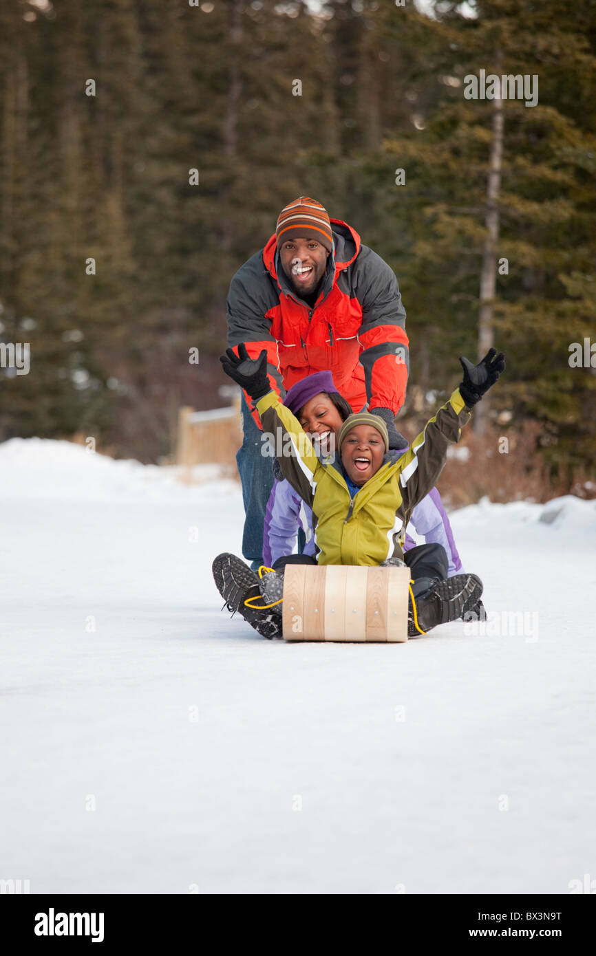 A Family Playing With A Toboggan In The Snow; Lake Louise, Alberta