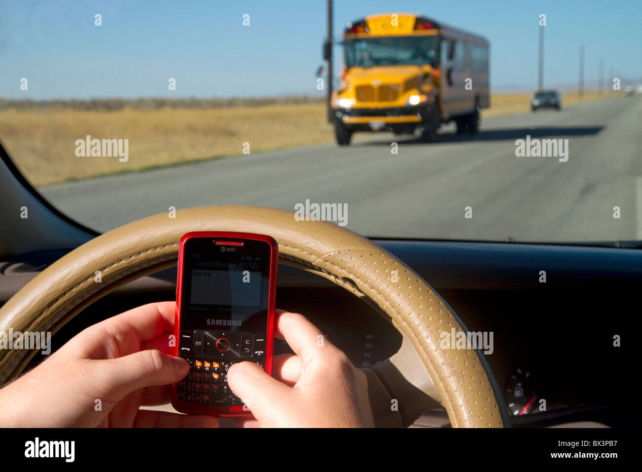 Text messaging on a cell phone while driving in Idaho, USA. MR Stock Photo