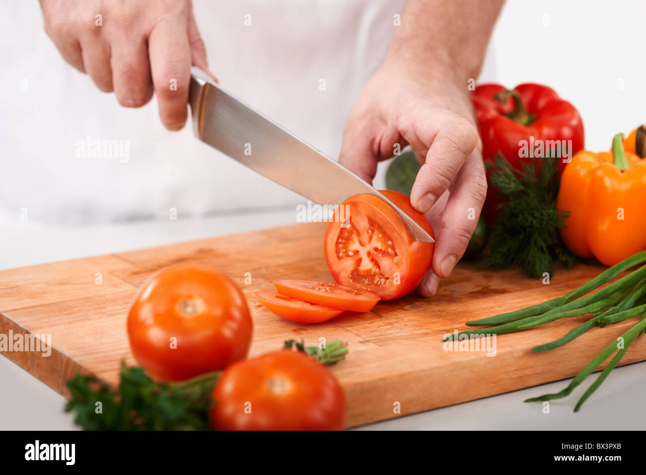 Image of male hand with knife cutting tomatoes on wooden chopping board  Stock Photo - Alamy