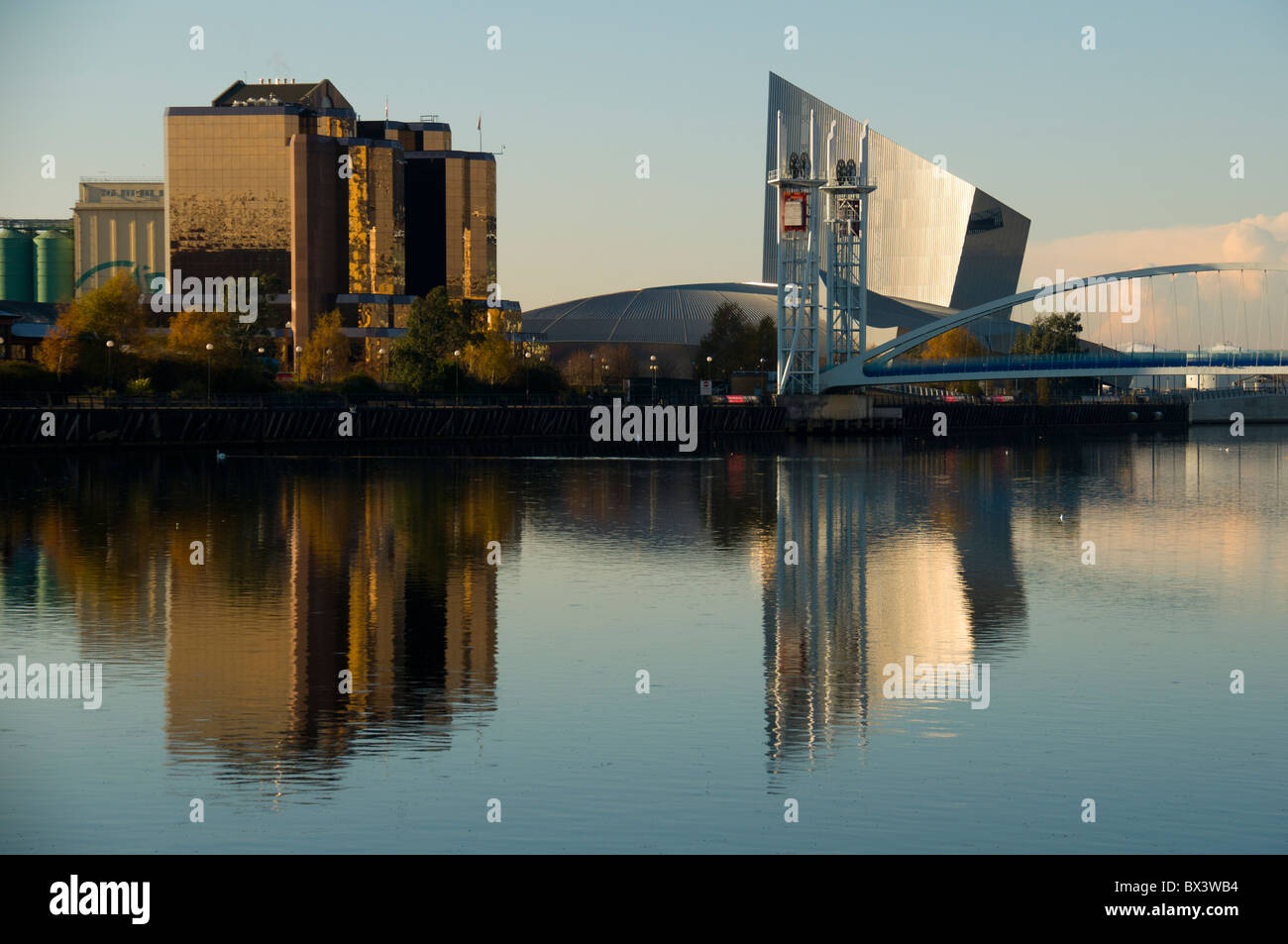 The Quay West building, Imperial War Museum North and the Millennium footbridge at Salford Quays, Manchester, England, UK Stock Photo