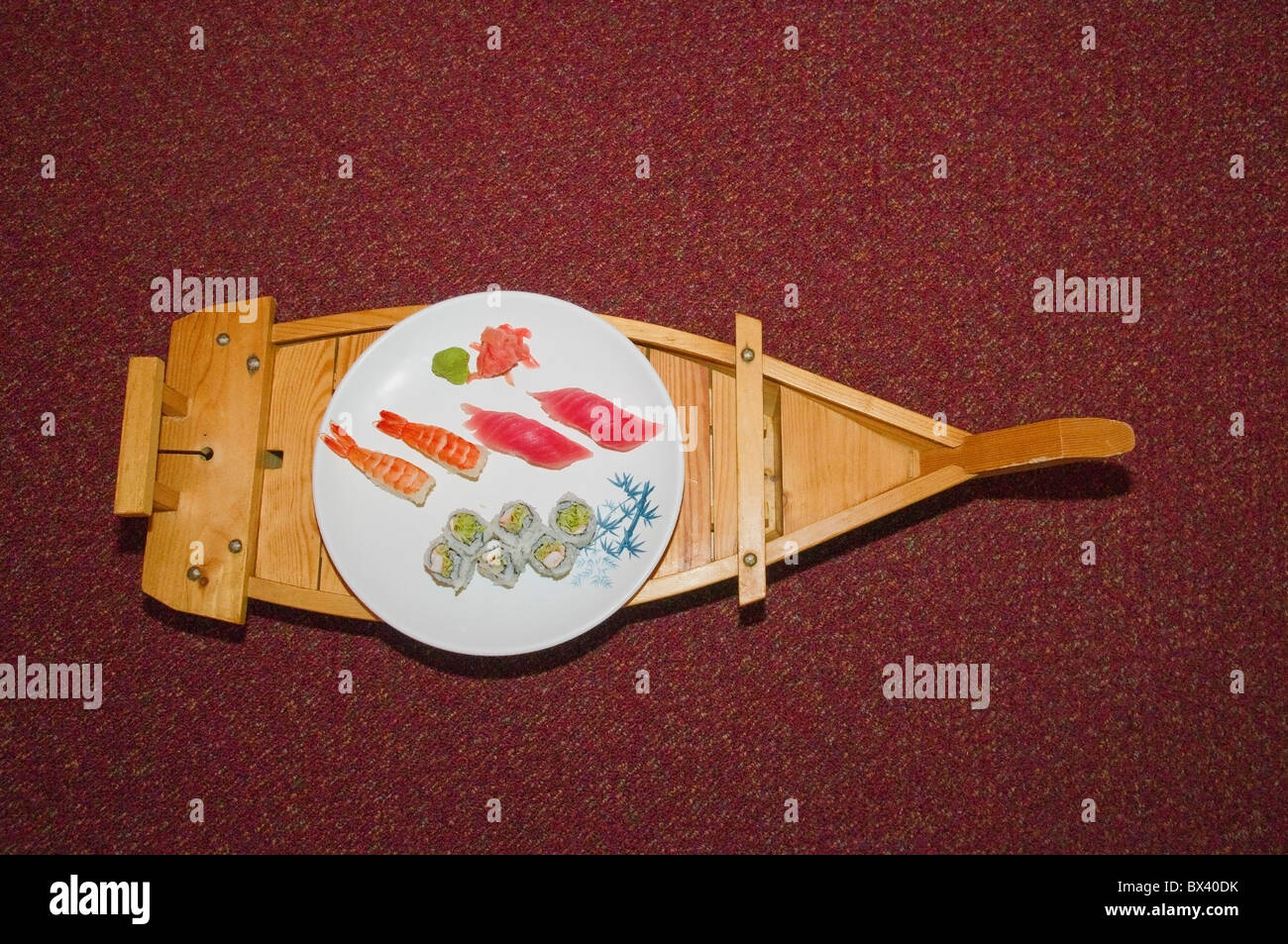 Wooden tray in the form of boat and white plate with sushi and sashimi,  Osaka Sushi Restaurant, Philadelphia, PA, USA Stock Photo