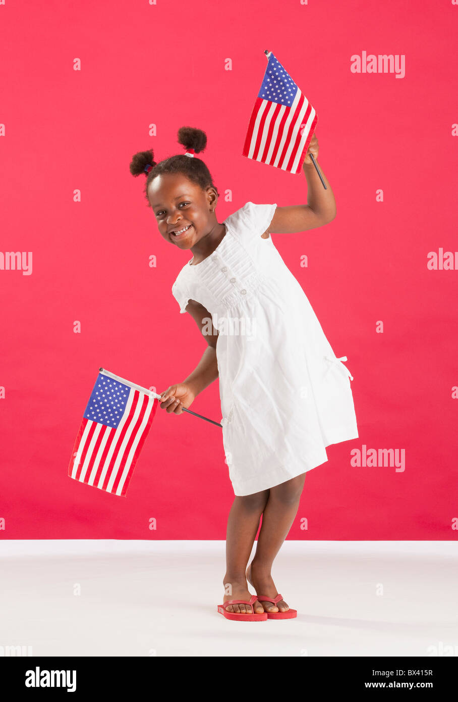 A Girl Holds Two American Flags Stock Photo