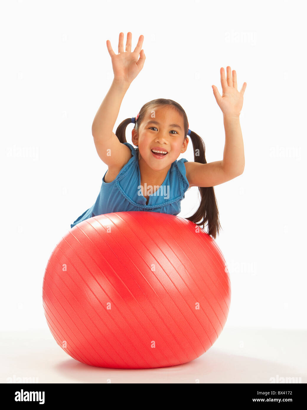 A Girl Balancing On A Large Red Exercise Ball Stock Photo Alamy