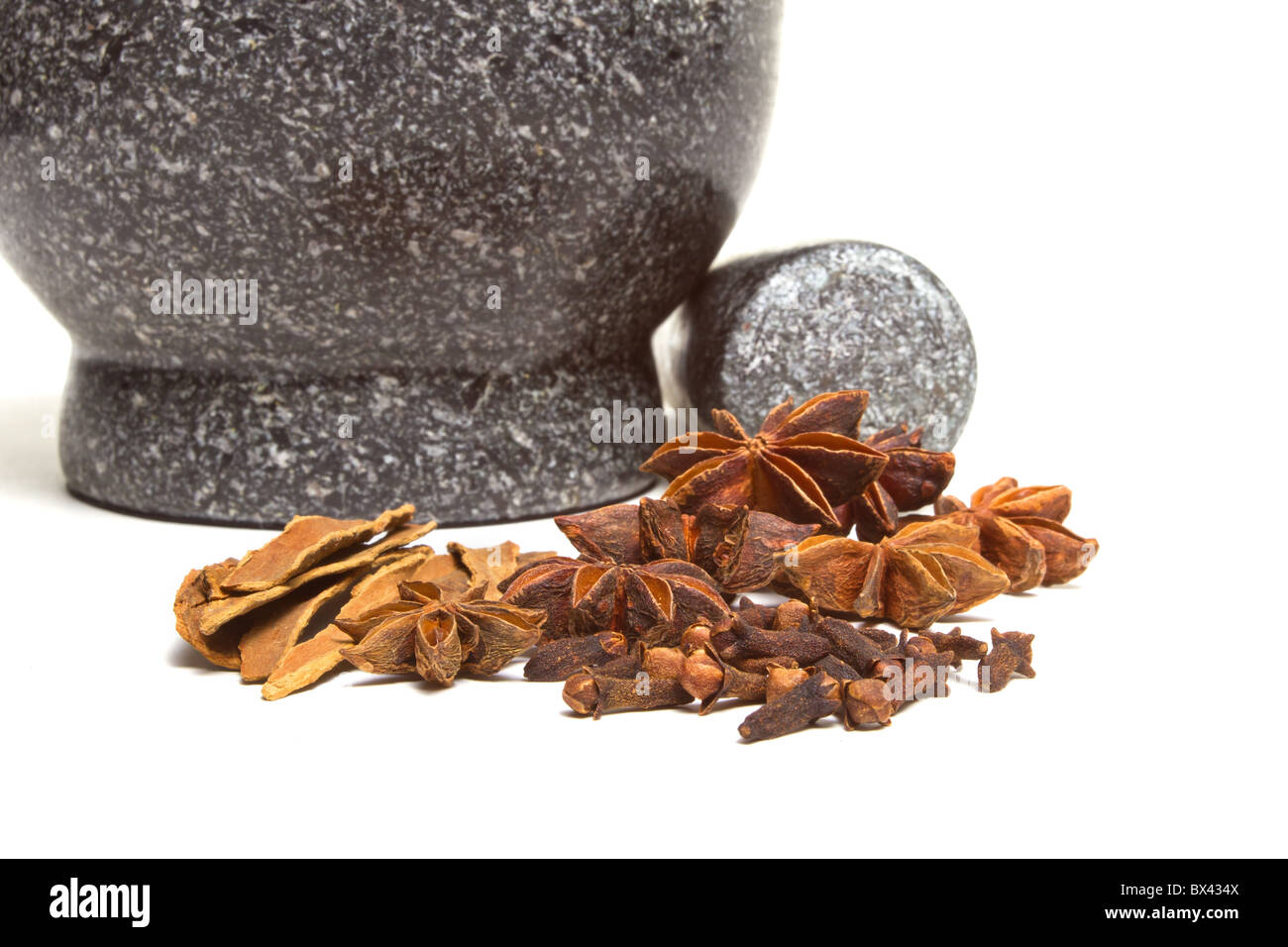 Granite mortar and pestle with winter spices of Cinnamon, cloves and Star Anise Stock Photo