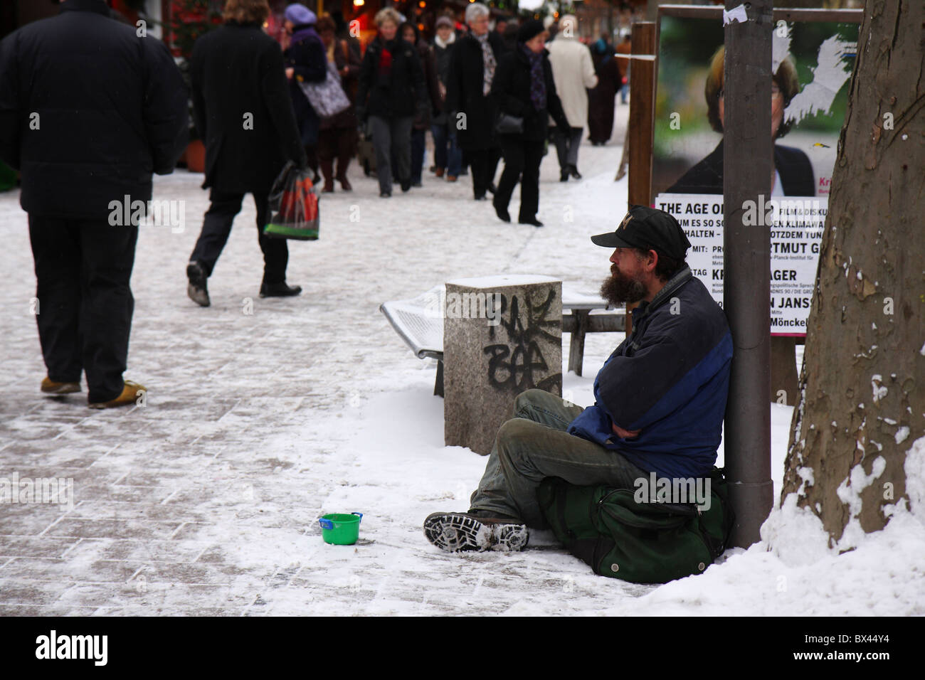 Homeless man on the snowy streets of Hamburg in winter time appealing