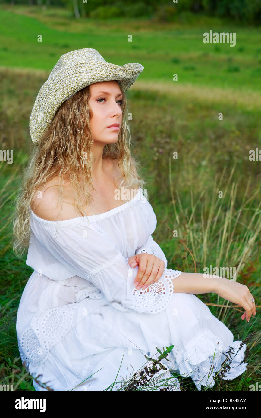 Beautiful woman sitting in a grass Stock Photo - Alamy