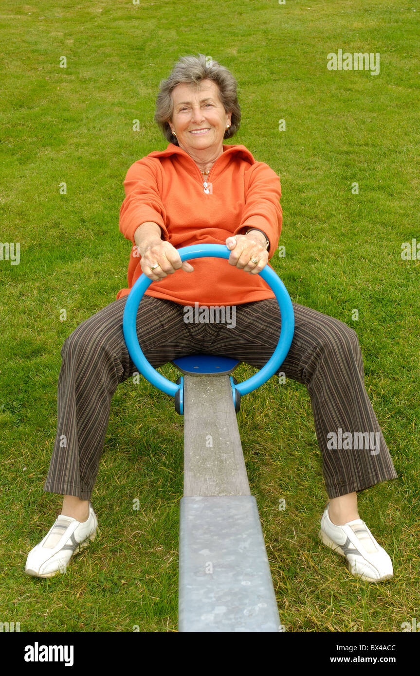 Elderly woman on children playground Stock Photo