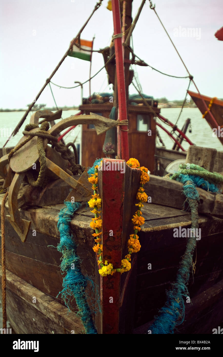 Fishing boat with a garland of marigolds on it's bow in a small fishing village on the Island of Diu, India Stock Photo