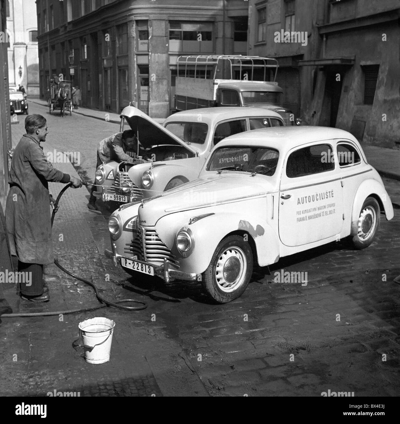 Prague - Czechoslovakia, 1950. Driving instructor washes Skoda 1102 Tudor after driving lesson. CTK Vintage Photo Stock Photo