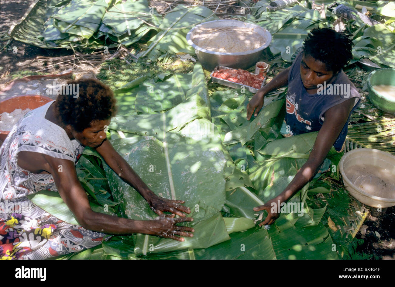 Women preparing cooking traditional laplap dishes, Sulphur Bay Village, Ipekel Ipeukel, Tanna Island, Vanuatu. Stock Photo