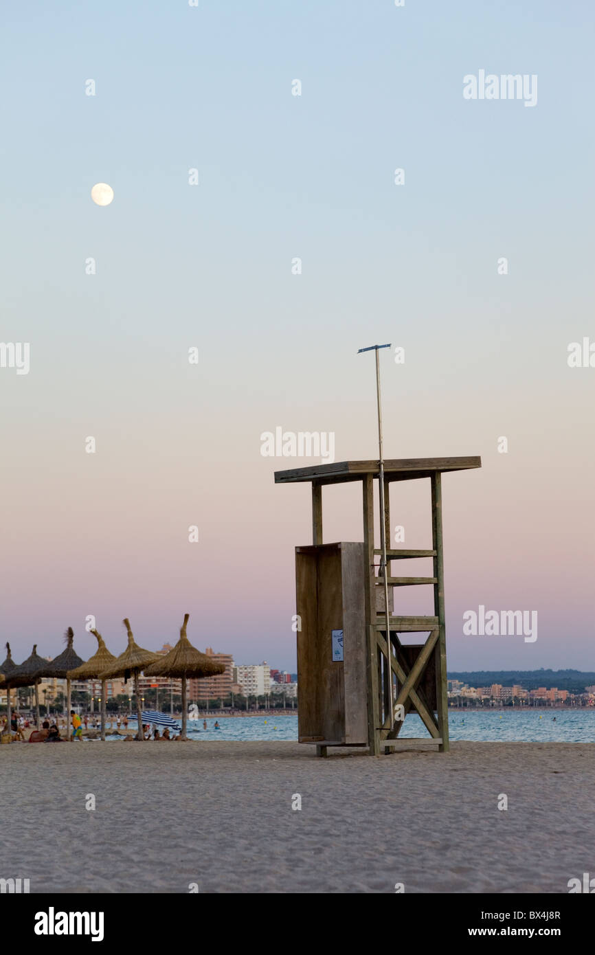 Empty lifeguard station on a beach at dusk, with the moon in the sky Stock Photo