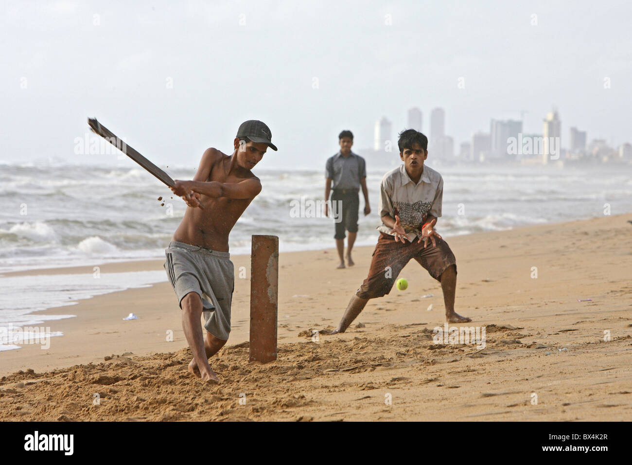 Teenagers playing cricket on the beach, Colombo, Sri Lanka Stock Photo