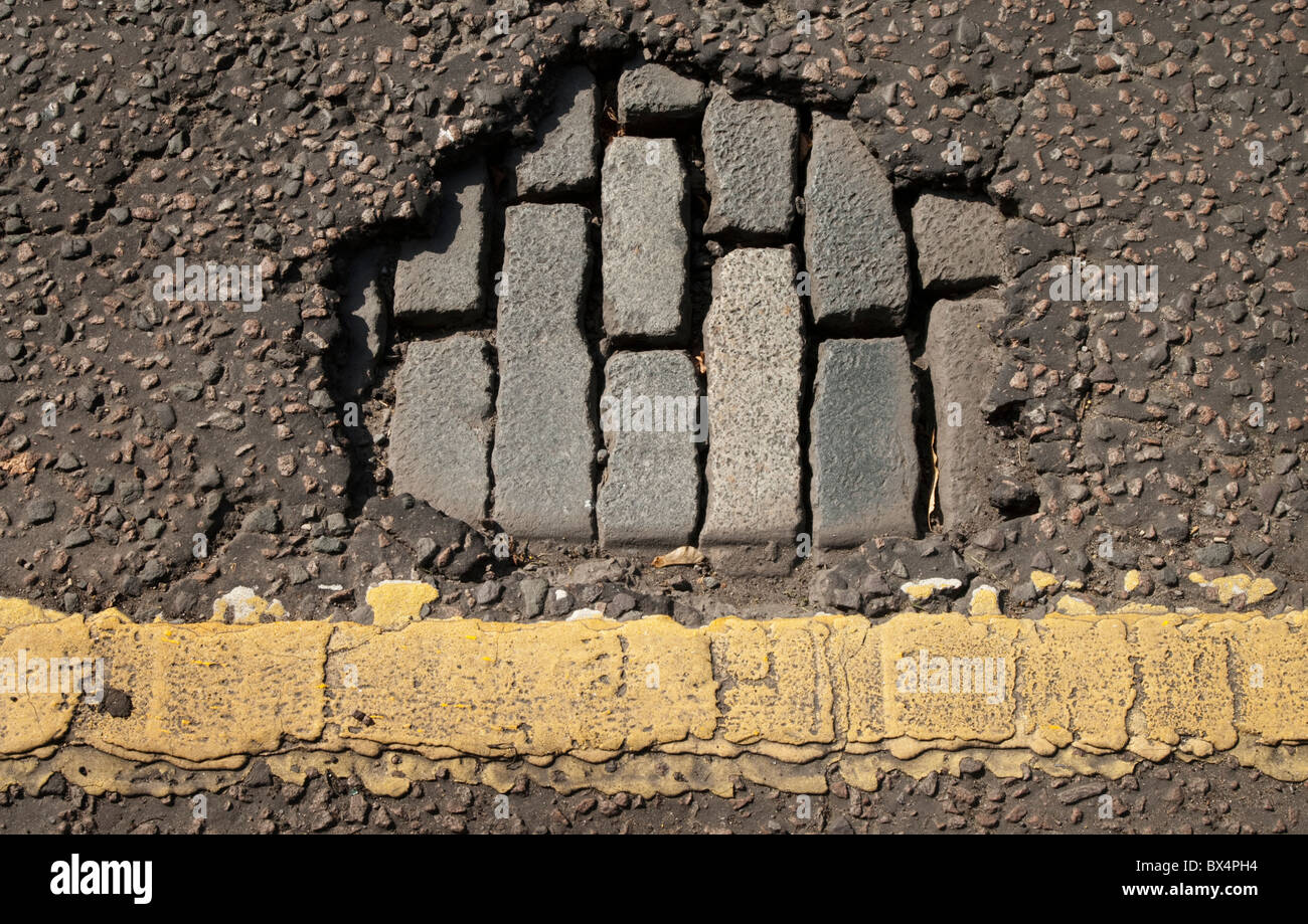 Hole in the road exposing old cobblestones. Stock Photo