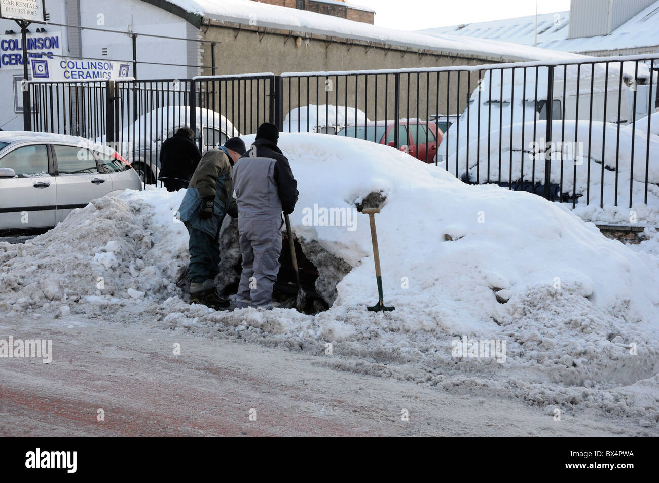 Two men dig out a car in Edinburgh that has been buried in snow during the severe winter of 2010 Stock Photo