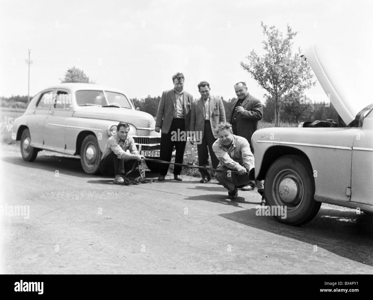 Disabled vehicle is being towed by rope to repair shop. Czechoslovakia 1963. (CTK Photo / Bedrich Krejci) Stock Photo