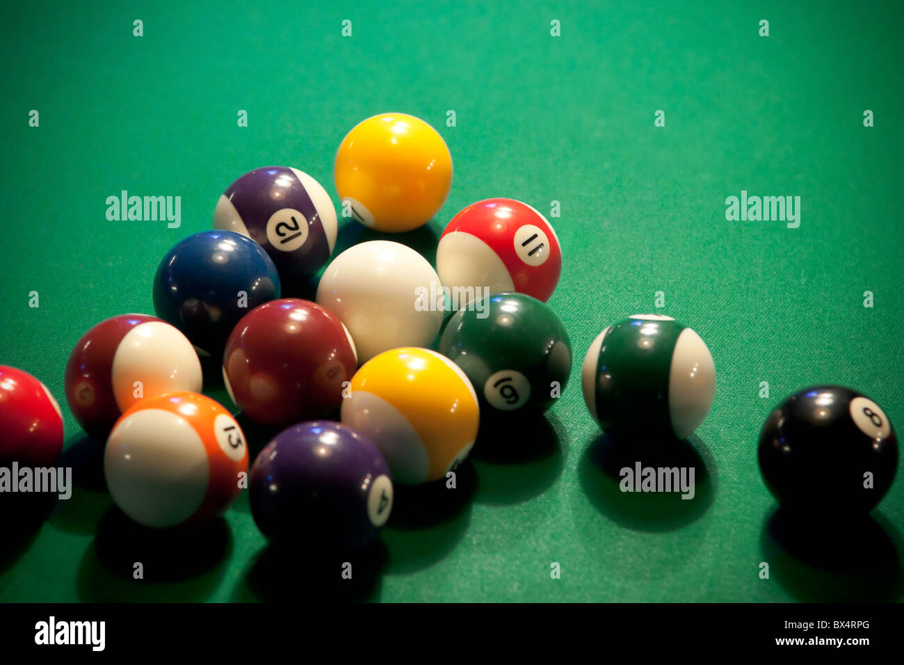 Colorful modern-style pool balls on a pool table already broken apart, waiting for the next player. Stock Photo