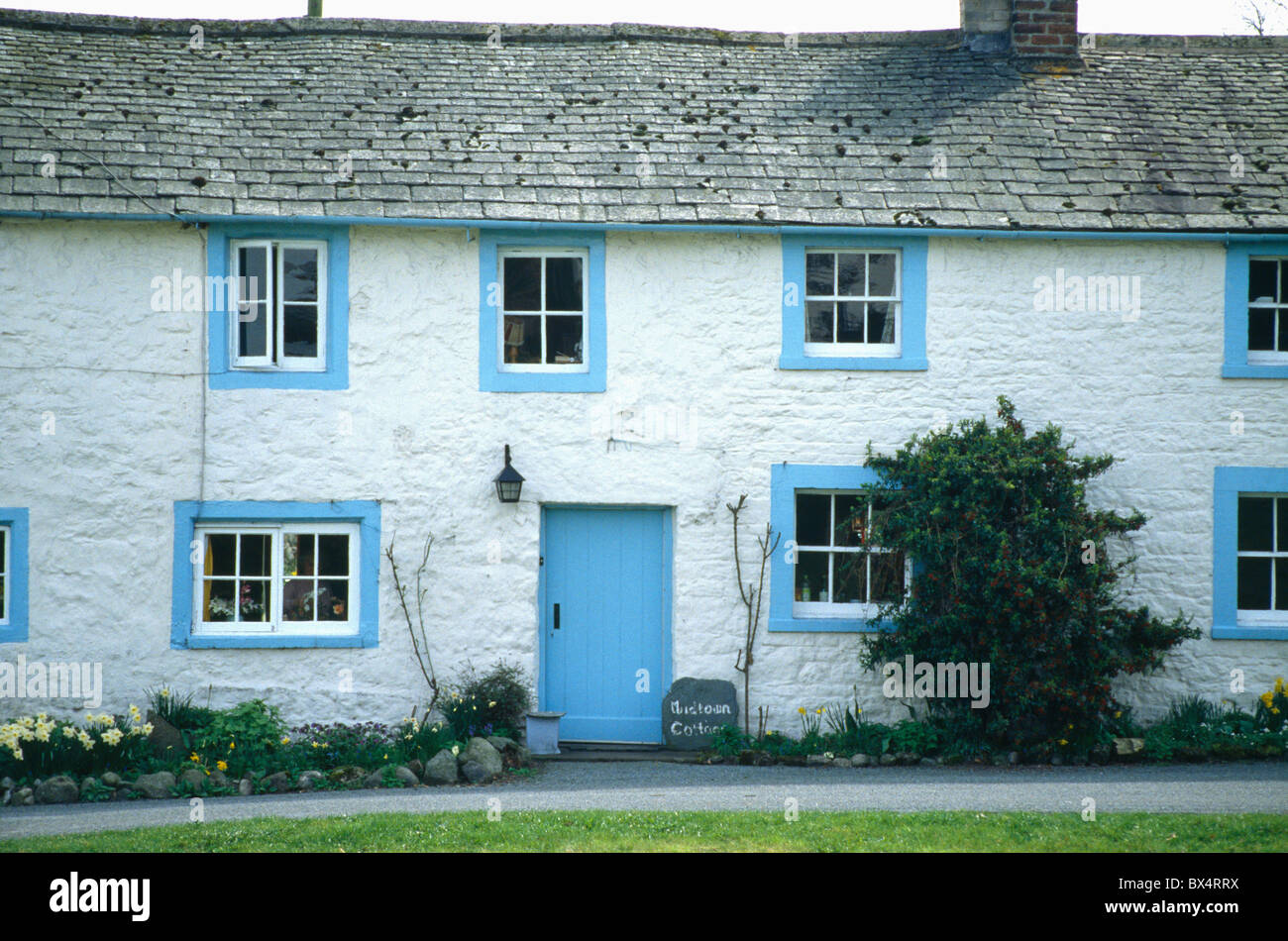 Traditional White Cottage With Blue Painted Door And Windows Stock