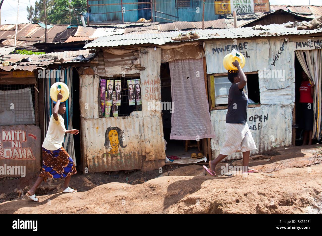 Women carrying water in the Kibera Slums, Nairobi, Kenya Stock Photo