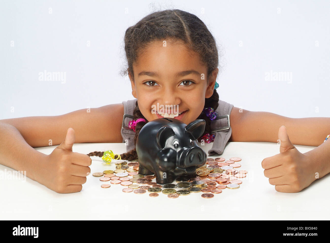 A girl with her savings and a piggy bank Stock Photo - Alamy