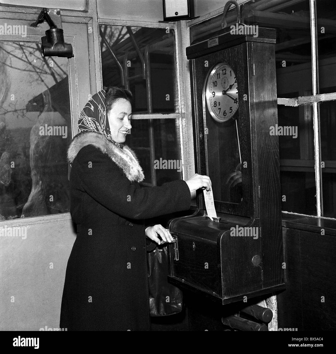 Czechoslovakia - Gottwaldov 1950. Shoe factory worker checks in and marks her time card at Svit shoe making factory. This plant Stock Photo