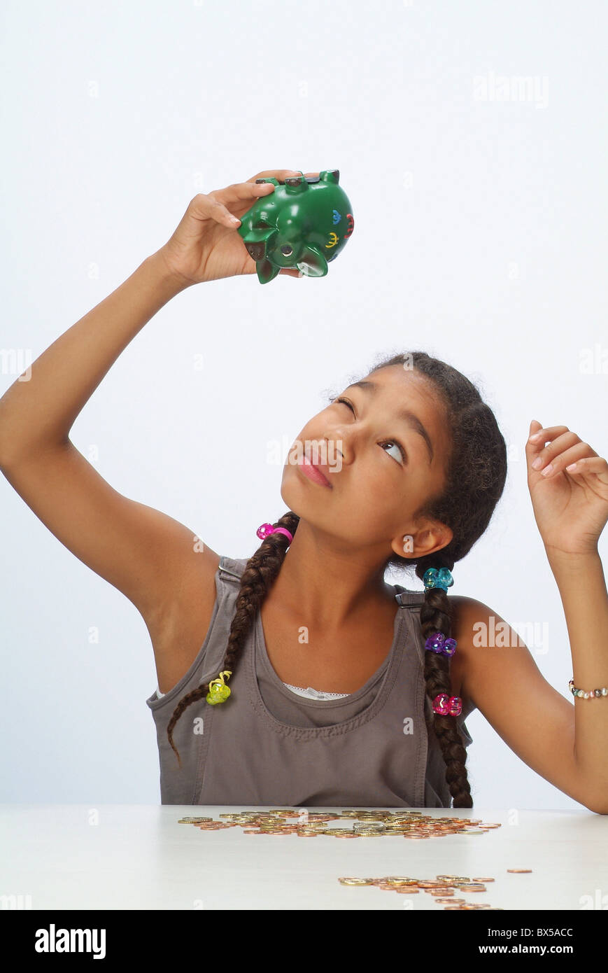 A girl with her savings and a piggy bank Stock Photo - Alamy