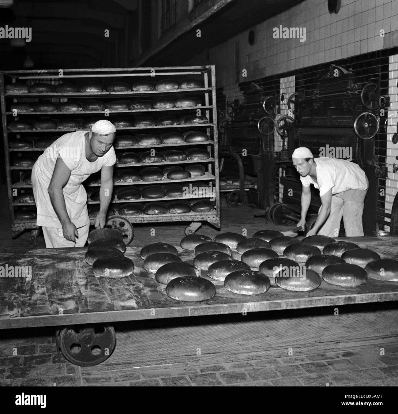 Czechoslovakia - Prague 1950.  Bakers take out freshly baked bread from oven. CTK Vintage Photo Stock Photo