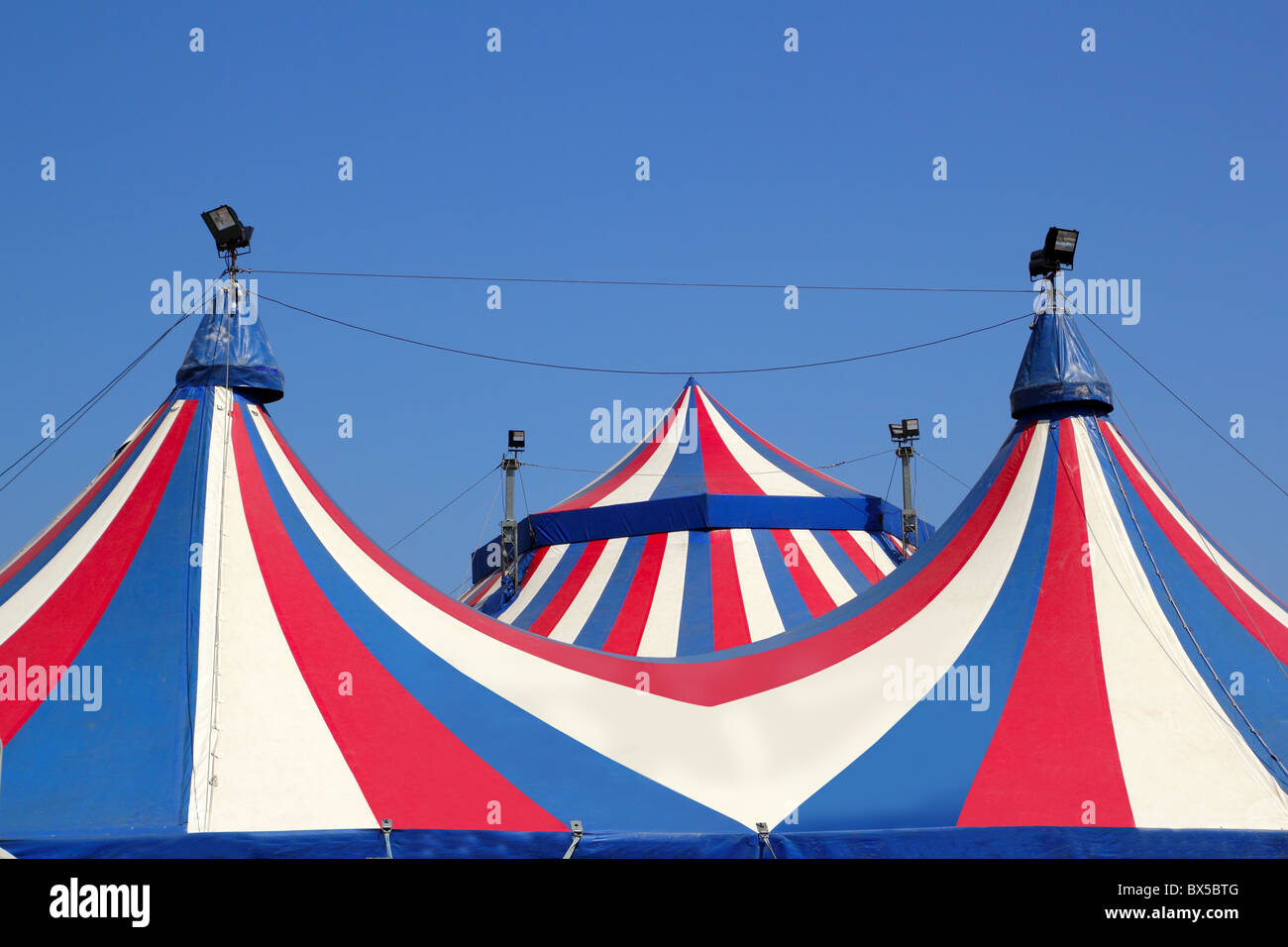 Circus tent under blue sky colorful stripes red white Stock Photo