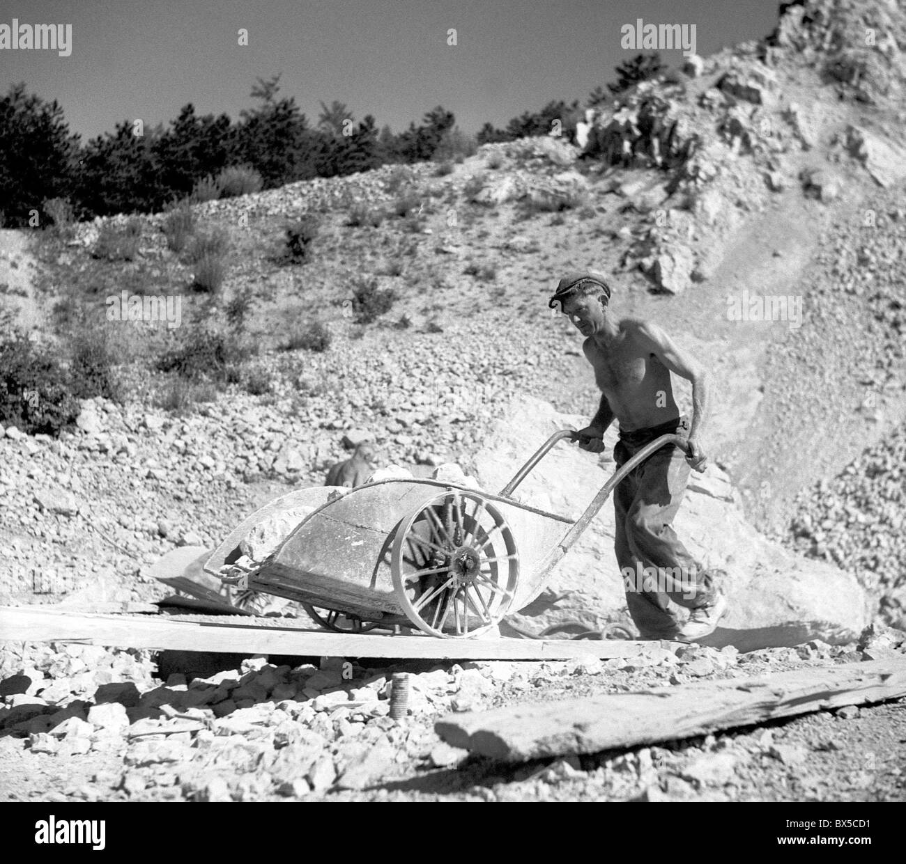Czechoslovakia, Stramberg 1948. Lime stone mine. Worker using cart to transport stone. CTK Vintage Photo Stock Photo