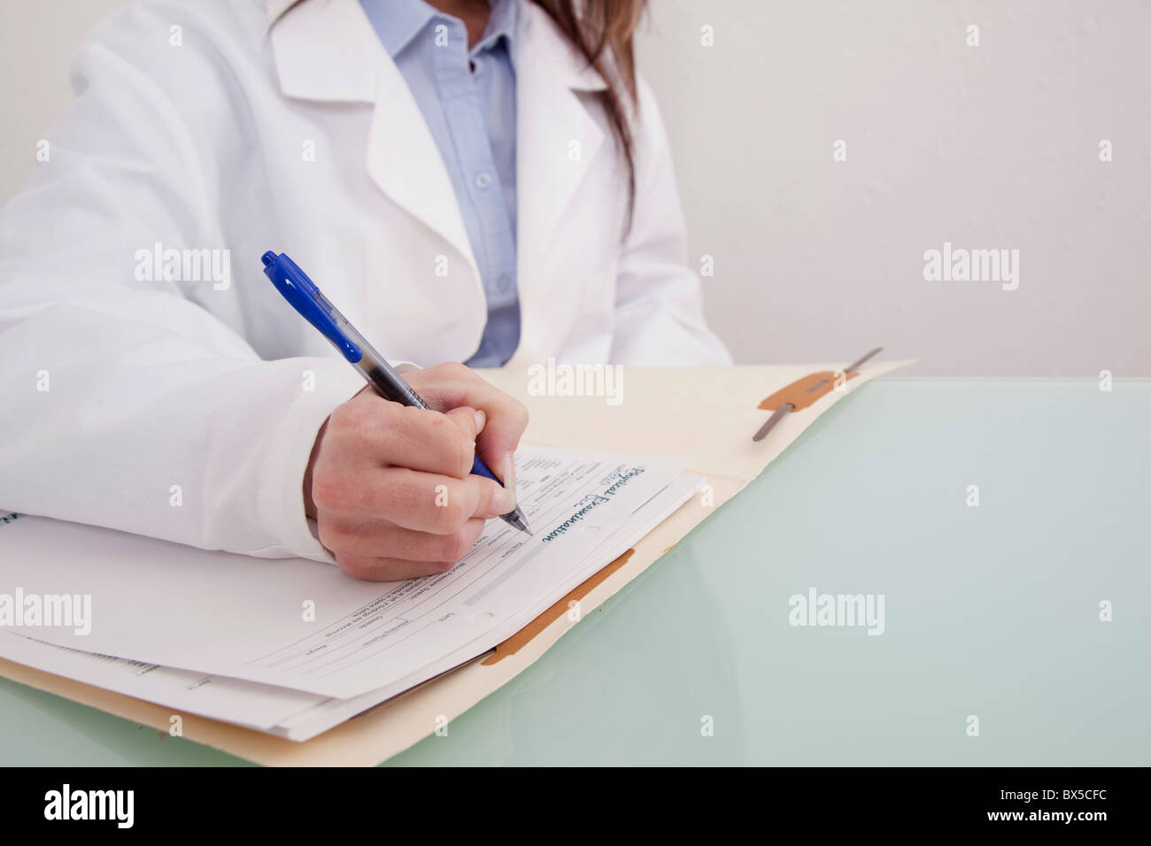 Close-up high-key of a doctor working on a patient file Stock Photo