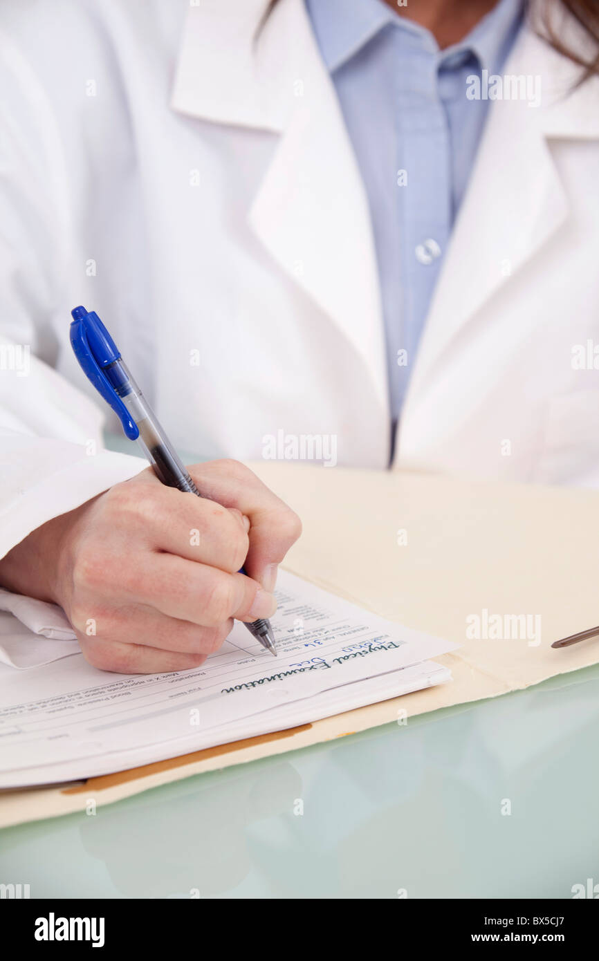 Doctor writing notes in a patient's chart Stock Photo
