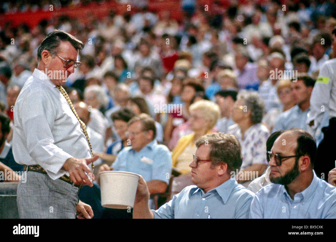 An usher collects contributions at a Billy Graham religious revival rally at Angel Stadium in Anaheim, CA. Stock Photo