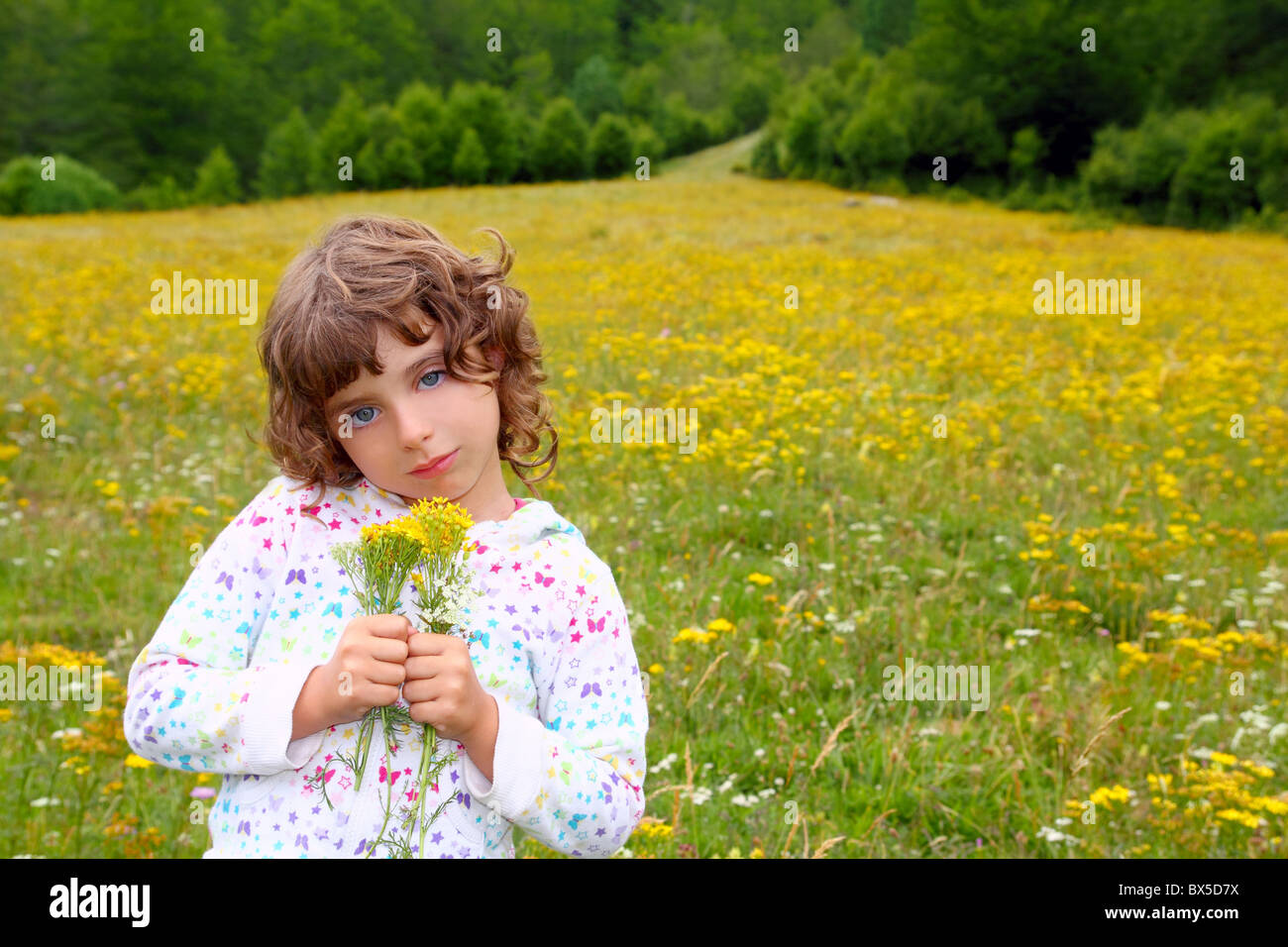 Girl picking flowers in yellow spring meadow beautiful scenic in
