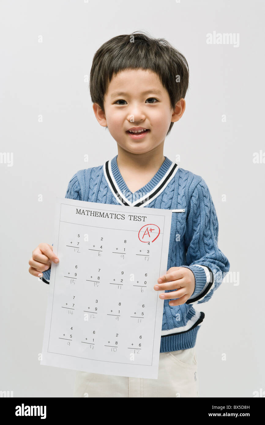 Boy holding math test with perfect score Stock Photo