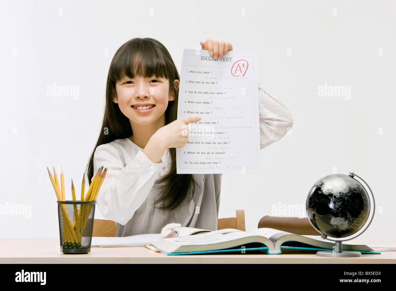 Girl holding English test with perfect score, close-up Stock Photo