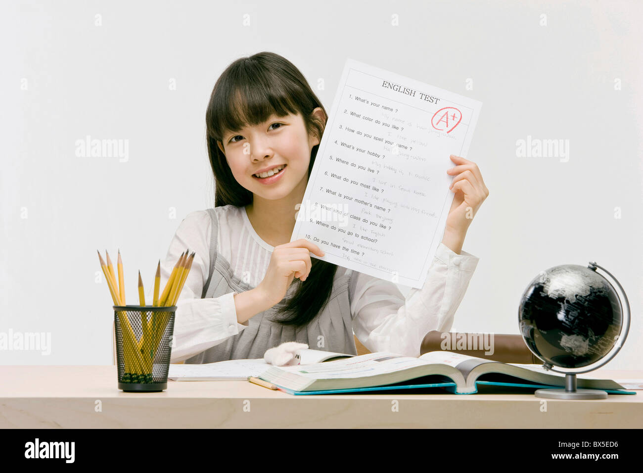 Girl holding English test with perfect score, close-up Stock Photo
