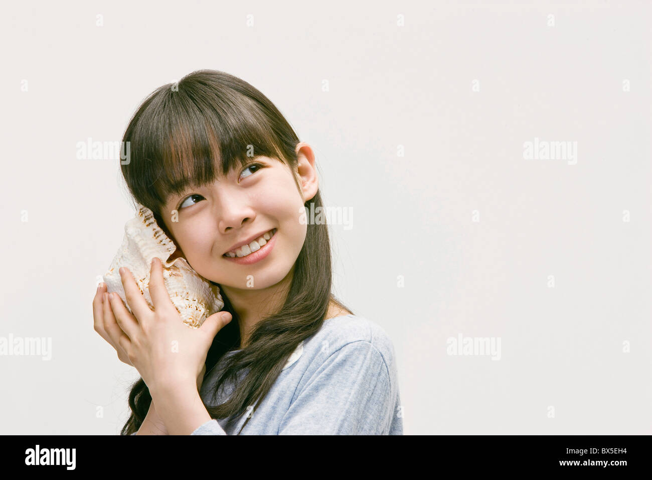 Woman holding conch shell ear hi-res stock photography and images - Alamy