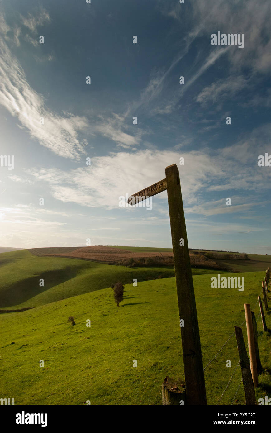 rolling green hills with footpath sign Stock Photo
