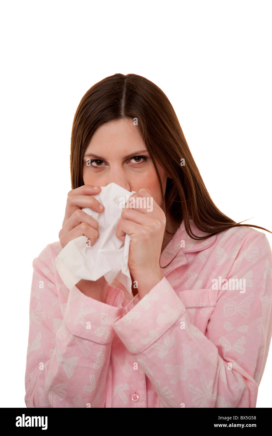 woman sneezing , got a cold wearing pyjamas. Stock Photo