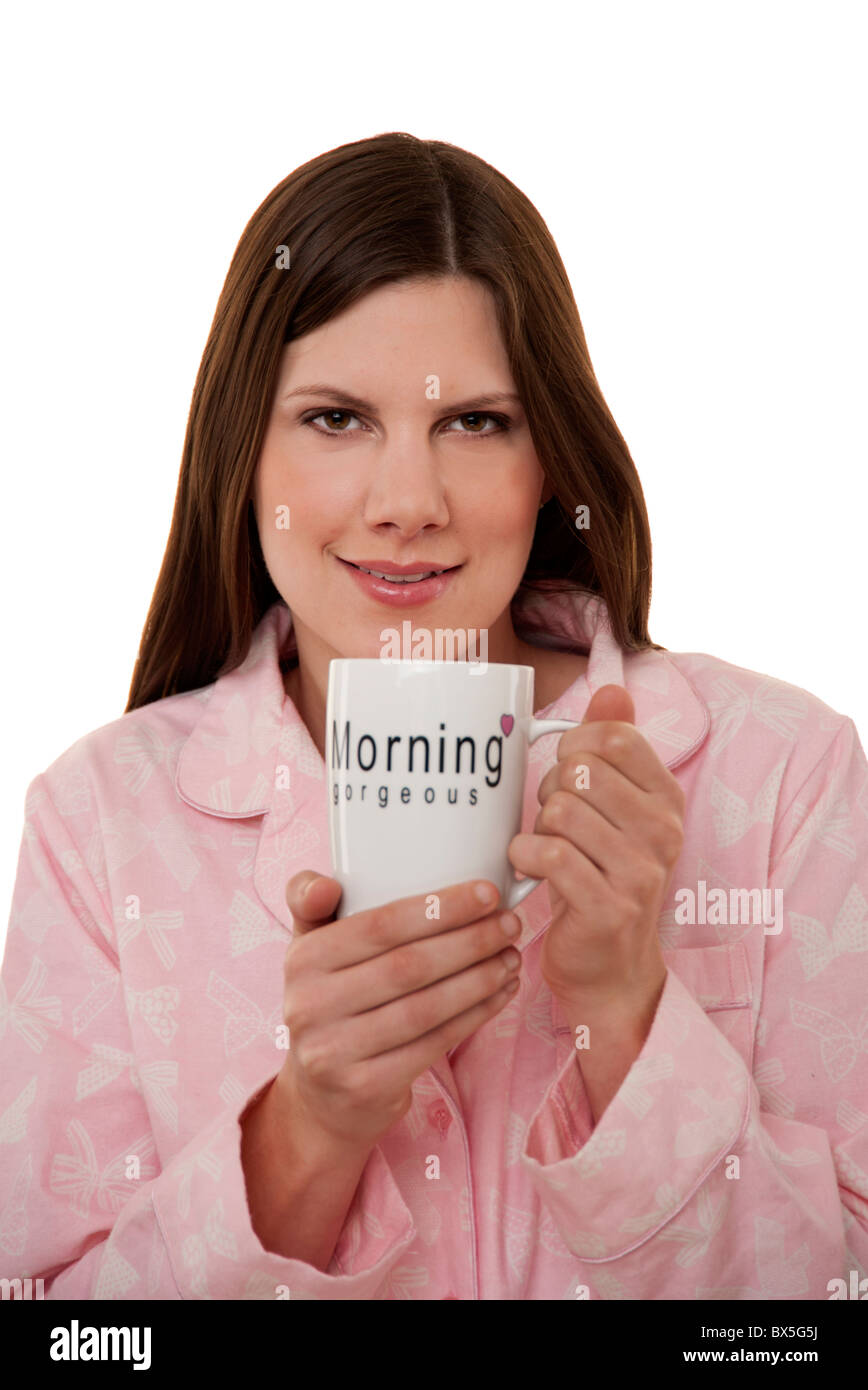 brunette woman holding mug of tea in her pyjamas Stock Photo