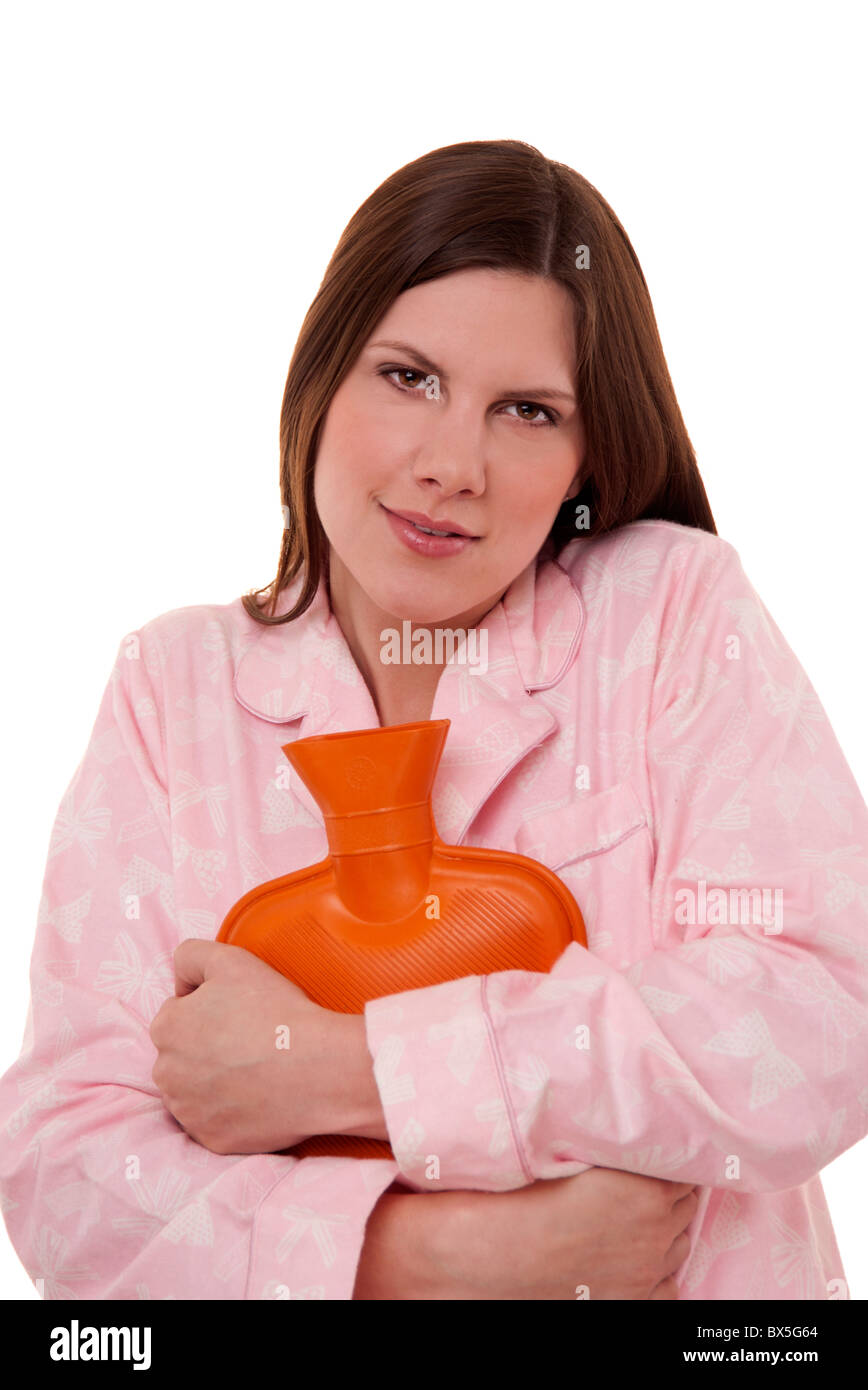 woman wearing pyjamas cuddling a hot water bottle for comfort & to