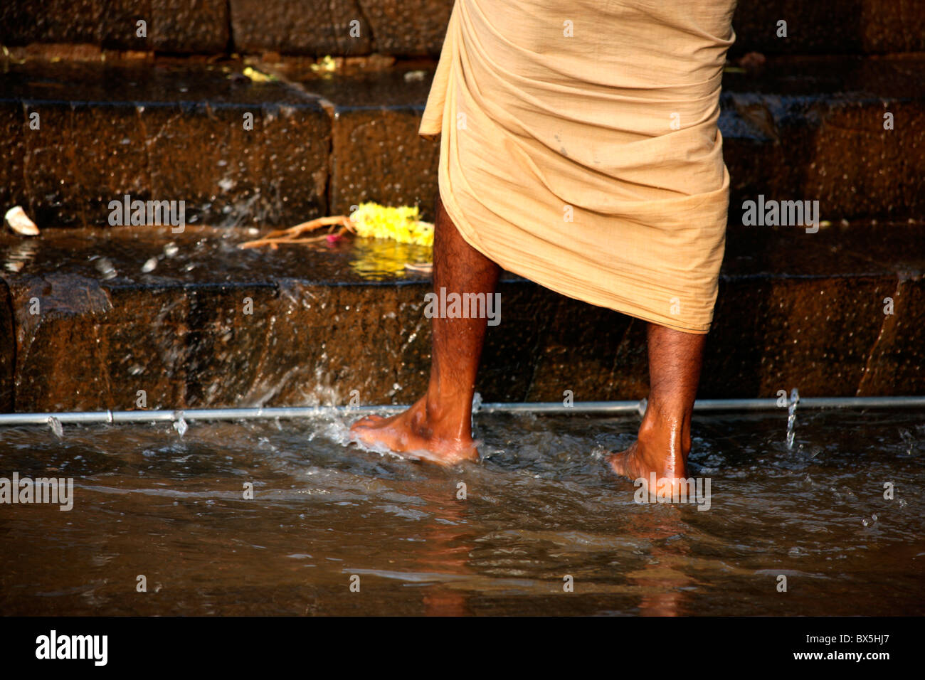 One pilgrim washing leg before climbing eighteen holy steps in