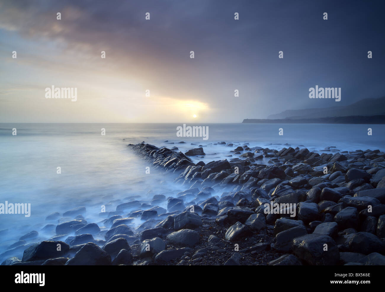 Sunset on stormy winter's day looking across Kimmeridge Bay from the remains of Clavell's Pier, Kimmeridge, Dorset, England, UK Stock Photo