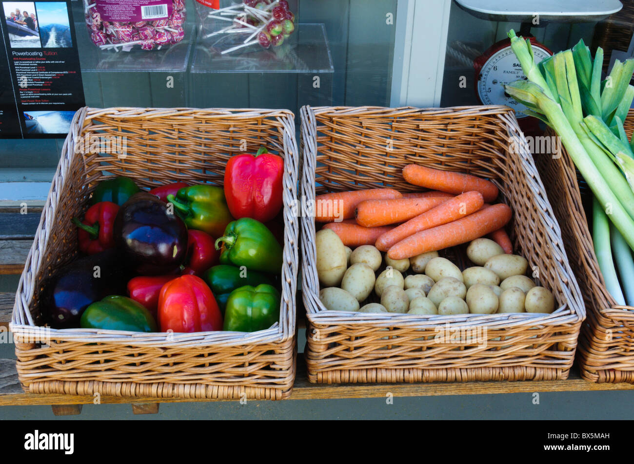 Vegetables for sale in wicker baskets in front of a shop at Brancaster