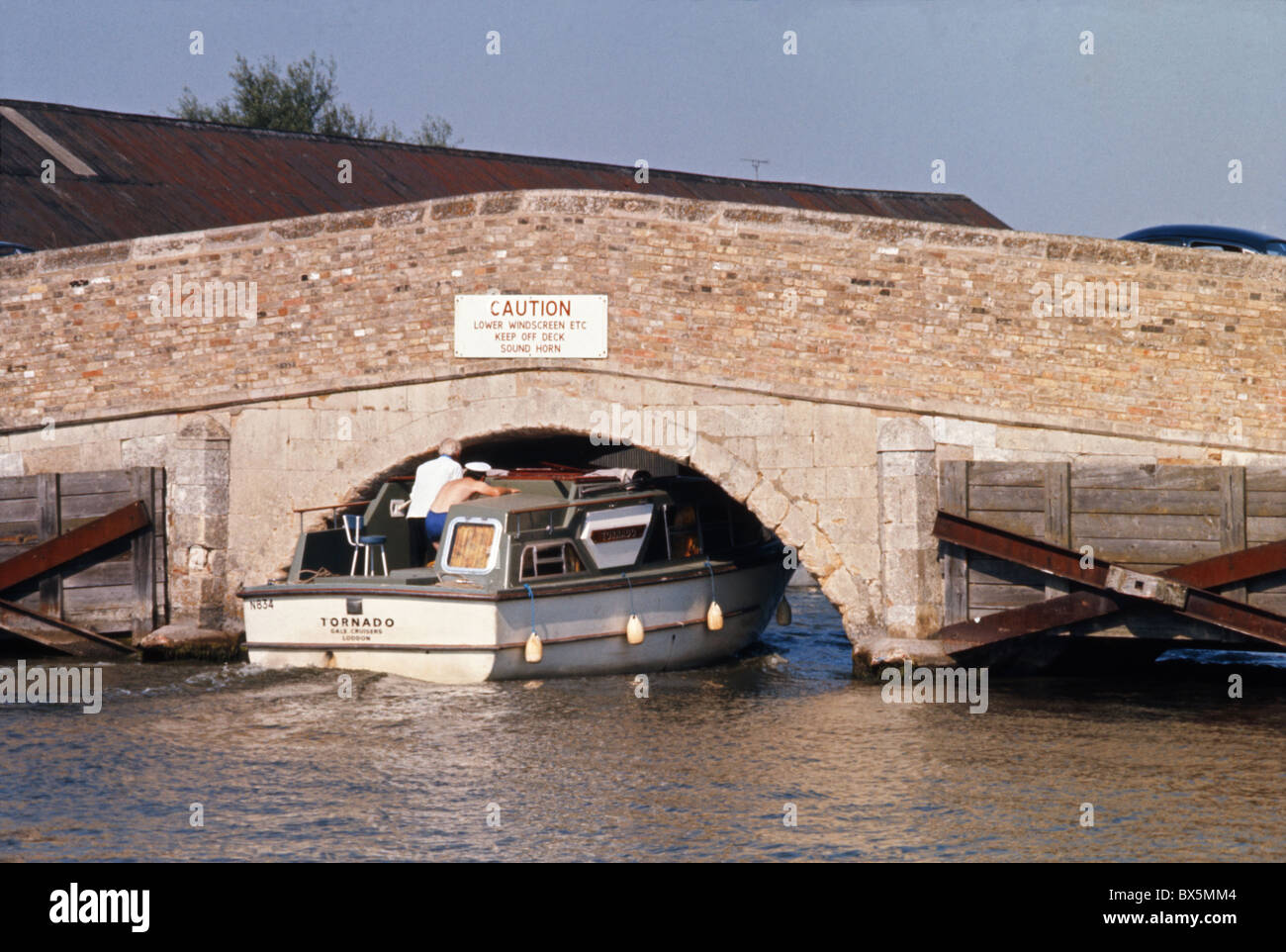 Motor cruiser passing under Potter Heigham bridge, Norfolk, England