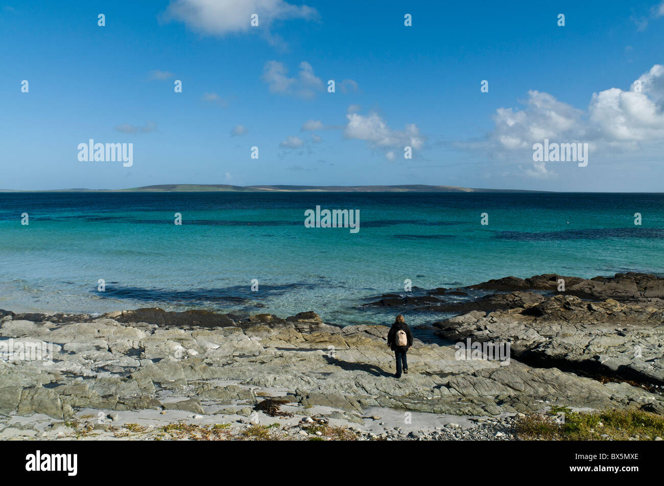 dh  EGILSAY ORKNEY tourist visitor on beach island of eday in distance islands person remote adult woman alone scotland Stock Photo