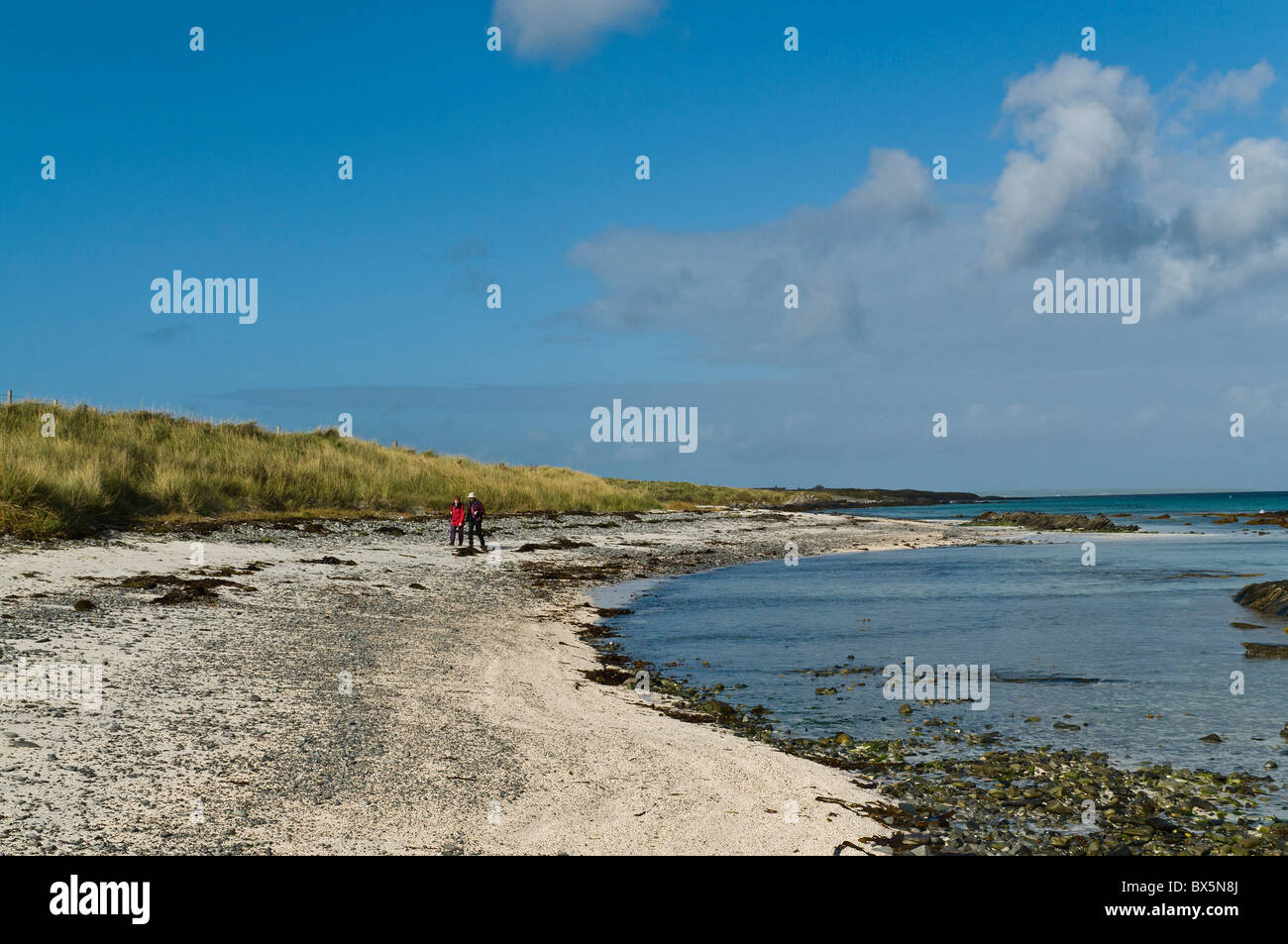 dh  EGILSAY ORKNEY Two tourist visitor hikers Egilsay sandy beach walking uk remote gb northern isles couple Stock Photo