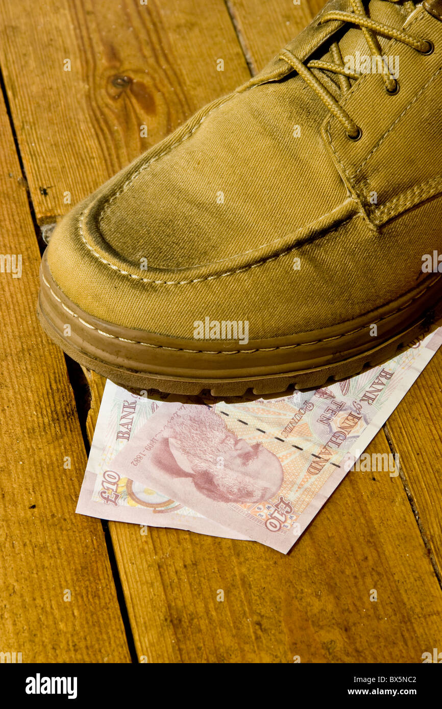 Shoe on top of two British sterling 10 pound notes Stock Photo